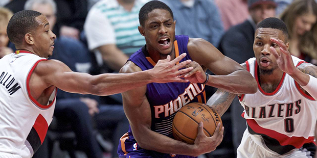 Phoenix Suns guard Brandon Knight, center, drives to the basket between Portland Trail Blazers guar...