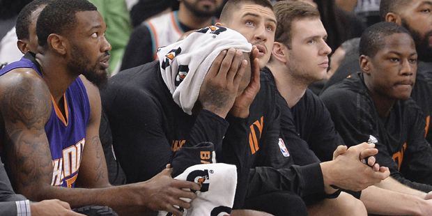 Phoenix Suns players watch play from the bench during the first half of an NBA basketball game agai...