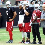 QBs Logan Thomas, Phillip Sims and Carson Palmer are joined by receiver Travis Harvey, running back Andre Ellington and coach Tom Moore during training camp Aug. 20. (Photo: Adam Green/Arizona Sports)