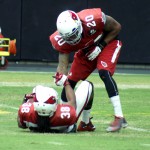 Safety Deone Bucannon helps running back Andre Ellington up during training camp Aug. 24. (Photo: Adam Green/Arizona Sports)