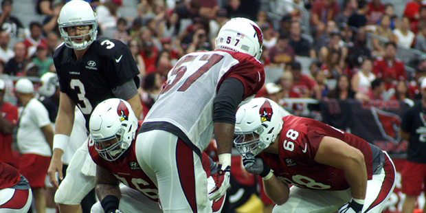 Carson Palmer looks over the defense while Alex Okafor gets ready to rush during Arizona Cardinals ...