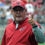 Head coach Bruce Arians gestures to fans during training camp Aug. 1, 2015 (Photo by Adam Green/Arizona Sports)