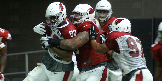 Calais Campbell (93) is wrapped up by guard Mike Iupati after coming down with an interception duri...