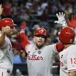 Philadelphia Phillies' Cameron Rupp, middle, celebrates his three-run home run against the Arizona Diamondbacks with Jeff Francoeur, left, and Freddy Galvis during the sixth inning of a baseball game Wednesday, Aug. 12, 2015, in Phoenix. (AP Photo/Ross D. Franklin)