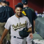 Oakland Athletics' Marcus Semien smiles in the dugout after scoring a run against the Arizona Diamondbacks during the third inning of a baseball game Friday, Aug. 28, 2015, in Phoenix. (AP Photo/Ross D. Franklin)