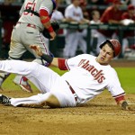 Arizona Diamondbacks' Jake Lamb slides across the plate as he scores against the Philadelphia Phillies on an RBI double by teammate David Peralta during the fifth inning of a baseball game, Monday, Aug. 10, 2015, in Phoenix. (AP Photo/Ralph Freso)