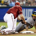 Oakland Athletics' Billy Burns, right, is tagged out by Arizona Diamondbacks first baseman Paul Goldschmidt in the first inning during a baseball game, Sunday, Aug. 30, 2015, in Phoenix. (AP Photo/Rick Scuteri)