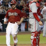 Arizona Diamondbacks' Ender Inciarte, left, scores on a triple by Paul Goldschmidt, as Philadelphia Phillies' Cameron Rupp watches the action in the infield during the fifth inning of a baseball game Wednesday, Aug. 12, 2015, in Phoenix. (AP Photo/Ross D. Franklin)