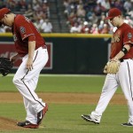 Arizona Diamondbacks' Aaron Hill, right, walks in to check on pitcher David Hernandez, left, who was hit on the leg by a line drive by Philadelphia Phillies' Andres Blanco during the sixth inning of a baseball game Wednesday, Aug. 12, 2015, in Phoenix. Hernandez left the game. (AP Photo/Ross D. Franklin)