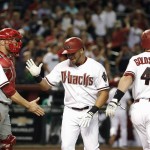 Arizona Diamondbacks' David Peralta, middle, is greeted at home plate by A.J. Pollock (11) and Paul Goldschmidt (44) after Peralta's grand slam, as Philadelphia Phillies catcher Cameron Rupp, second from left, gwaits during the second inning of a baseball game Tuesday, Aug. 11, 2015, in Phoenix. (AP Photo/Ross D. Franklin)