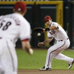 Arizona Diamondbacks' Paul Goldschmidt, right, fields a grounder hit by Philadelphia Phillies' Chase Utley as pitcher Jeremy Hellickson (58) runs over to cover first base for the out during the first inning of a baseball game Tuesday, Aug. 11, 2015, in Phoenix. (AP Photo/Ross D. Franklin)