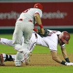 Arizona Diamondbacks' David Peralta, bottom, is tagged out by Philadelphia Phillies' Cesar Hernandez after getting caught in a run down between second and third base during the fifth inning of a baseball game, Monday, Aug. 10, 2015, in Phoenix. (AP Photo/Ralph Freso)