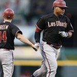 Arizona Diamondbacks Yasmany Tomas is congratulated by third base coach Andy Green (14) as he rounds the bases with a solo home run off Cincinnati Reds starting pitcher David Holmberg during the  fourth inning of a baseball game, Friday, Aug. 21, 2015, in Cincinnati. (AP Photo/Gary Landers)