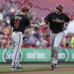 Arizona Diamondbacks' A.J. Pollock, right, is congratulated by third base coach Andy Green  on a solo home run off Cincinnati Reds starting pitcher David Holmberg during the first inning of a baseball game, Friday, Aug. 21, 2015, in Cincinnati. (AP Photo/Gary Landers)