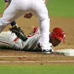 Philadelphia Phillies' Cesar Hernandez, bottom, dives back to first base ahead of the tag by Arizona Diamondbacks' Paul Goldschmidt on a pick-off attempt during the third inning of a baseball game, Monday, Aug. 10, 2015, in Phoenix. (AP Photo/Ralph Freso)