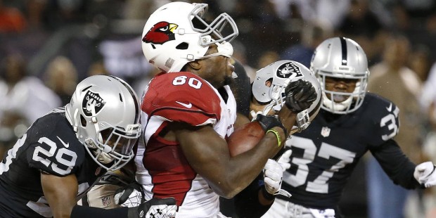 Arizona Cardinals tight end Ifeanyi Momah (80) is hit by Oakland Raiders' Brandian Ross (29) and Ta...