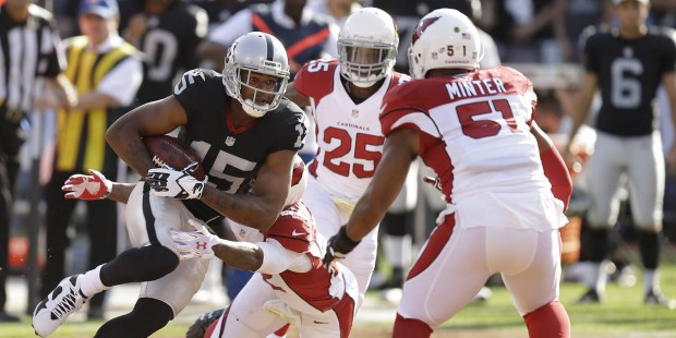 Oakland Raiders wide receiver Michael Crabtree (15) is tackled by Arizona Cardinals defensive back ...