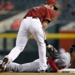 St. Louis Cardinals' Thomas Pham, right, dives back to first base just ahead of a tag by Arizona Diamondbacks' Paul Goldschmidt on a pick-off throw during the first inning of a baseball game Wednesday, Aug. 26, 2015, in Phoenix. (AP Photo/Ross D. Franklin)