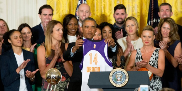 President Barack Obama holds up an Phoenix Mercury basketball jersey presented to him by the team d...
