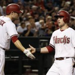 Arizona Diamondbacks' Chris Owings, right, shakes hands with A.J. Pollock (11) after Owings scored a run against the Philadelphia Phillies during the second inning of a baseball game Tuesday, Aug. 11, 2015, in Phoenix. (AP Photo/Ross D. Franklin)