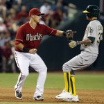 Arizona Diamondbacks third baseman Jake Lamb, left, tags out Oakland Athletics' Jesse Chavez trying to run to third base on a ball hit by Billy Burns in the fifth inning during a baseball game, Sunday, Aug. 30, 2015, in Phoenix. (AP Photo/Rick Scuteri)