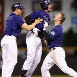 Colorado Rockies' pinch-hitter Ben Paulsen, middle, celebrates with Nick Hundley, left, and Brandon Barnes after his walk off single brought in two runs against the Arizona Diamondbacks in the bottom of the ninth inning of a baseball game, Monday, Aug. 31, 2015, in Denver. Colorado won 5-4. (AP Photo/David Zalubowski)