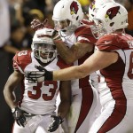 Arizona Cardinals running back Kerwynn Williams (33) celebrates with teammates after scoring on a 10-yard touchdown reception against the Oakland Raiders during the second half of an NFL preseason football game in Oakland, Calif., Sunday, Aug. 30, 2015. (AP Photo/Ben Margot)
