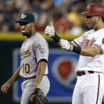 Arizona Diamondbacks' David Peralta, right, celebrates his run-scoring double as he stands at second base, while Oakland Athletics' Marcus Semien watches during the sixth inning of a baseball game Friday, Aug. 28, 2015, in Phoenix. (AP Photo/Ross D. Franklin)