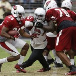 Arizona Cardinals' Andre Ellington (38) tries to find running room as Bobby Massie (70) blocks Alex Okafor (57) during an NFL football training camp practice Thursday, Aug. 13, 2015, in Glendale, Ariz. (AP Photo/Ross D. Franklin)