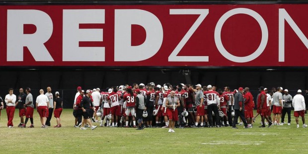 Arizona Cardinals players and staff meet on the field at University of Phoenix Stadium at the end o...
