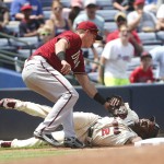 Atlanta Braves' Michael Bourn (2) is tagged out at third base by Arizona Diamondbacks third baseman Jake Lamb (19) while attempting to advance on a wild throw to second base in the third innings of a baseball game Sunday, Aug. 16, 2015, in Atlanta. (AP Photo/John Bazemore)