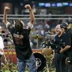 Hall of Fame pitcher Randy Johnson reacts as he is presented with a Rush 40th anniversary Neil Peart signature drum set during a ceremony retiring his No. 51 Arizona Diamondbacks jersey, before a baseball game between the Cincinnati Reds and the Diamondbacks, Saturday, Aug. 8, 2015, in Phoenix. (AP Photo/Ralph Freso)
