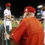 Washington Nationals' Ryan Zimmerman (11) shakes hands with manager Matt Williams (9) with Yunel Escobar, at right, as they celebrate Zimmerman's scoring during the eighth inning of a baseball game against the Arizona Diamondbacks at Nationals Park, Tuesday, Aug. 4, 2015, in Washington. The Nationals won 5-4. (AP Photo/Alex Brandon)