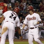 Arizona Diamondbacks' Aaron Hill, right, celebrates his two-run home run with Yasmany Tomas (24) as Philadelphia Phillies' Cameron Rupp, left, looks to the infield during the second inning of a baseball game Tuesday, Aug. 11, 2015, in Phoenix. (AP Photo/Ross D. Franklin)