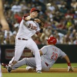 Arizona Diamondbacks' Jake Lamb, second from right, forces out Cincinnati Reds' Brayan Pena (29) at third on a bunt-attempt by Reds' Raisel Iglesias during the fifth inning of a baseball game, Friday, Aug. 7, 2015, in Phoenix. (AP Photo/Matt York)