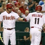 Arizona Diamondbacks' A.J Pollock (11) is congratulated by teammate David Peralta after scoring a run against the Philadelphia Phillies during the fifth inning of a baseball game, Monday, Aug. 10, 2015, in Phoenix. (AP Photo/Ralph Freso)
