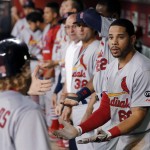 St. Louis Cardinals' Mark Reynolds, bottom left, is greeted in the dugout by Thomas Pham, right, assistant hitting coach Bill Mueller, left, and others after Reynolds hit a home run against the Arizona Diamondbacks during the fifth inning of a baseball game Wednesday, Aug. 26, 2015, in Phoenix. (AP Photo/Ross D. Franklin)