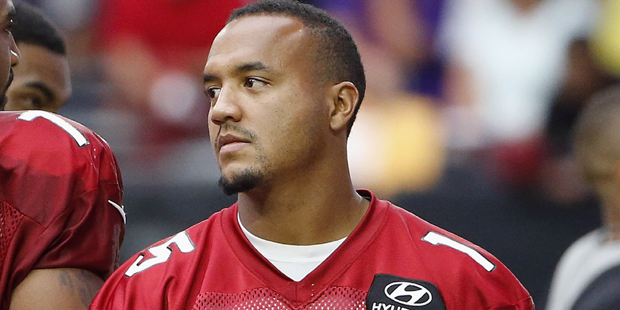 An injured Arizona Cardinals' Michael Floyd paces the sidelines while holding a football during an ...