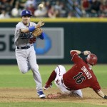 Los Angeles Dodgers' Ronald Torreyes, left, throws to first over Arizona Diamondbacks' Chris Owings to complete a double play during the eighth inning of a baseball game, Sunday, Sept. 13, 2015, in Phoenix. The Dodgers defeated the Diamondbacks 4-3. (AP Photo/Ralph Freso)