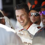San Francisco Giants' Buster Posey smiles in the dugout after hitting a three-run homer against the Arizona Diamondbacks during the sixth inning of a baseball game, Sunday, Sept. 20, 2015, in San Francisco. (AP Photo/George Nikitin)