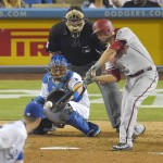 Arizona Diamondbacks' A.J. Pollock hits a solo home run as Los Angeles Dodgers starting pitcher Alex Wood, lower left, and catcher A.J. Ellis, second from left, watches along with home plate umpire Hunter Wendelstedt during the seventh inning of a baseball game, Tuesday, Sept. 22, 2015, in Los Angeles. (AP Photo/Mark J. Terrill)