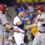 Arizona Diamondbacks' Paul Goldschmidt, right, is congratulated by Jarrod Saltalamacchia, left, as Los Angeles Dodgers catcher A.J. Ellis stands at the plate after hitting a solo home run during the seventh inning of a baseball game, Tuesday, Sept. 22, 2015, in Los Angeles. (AP Photo/Mark J. Terrill)