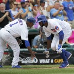 Chicago Cubs third base coach Gary Jones (1) greets Dexter Fowler, as Fowler rounds third, after hitting a home run off Arizona Diamondbacks starting pitcher Robbie Ray, during the fifth inning of a baseball game Saturday, Sept. 5, 2015, in Chicago. (AP Photo/Charles Rex Arbogast)
