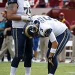 St. Louis Rams quarterback Nick Foles (5) holds his leg as offensive tackle Rob Havenstein (79) helps him up during the second half of an NFL football game against the Washington Redskins in Landover, Md., Sunday, Sept. 20, 2015. Foles was injured in the team's last possession of the game. The Redskins won 24-10. (AP Photo/Alex Brandon)