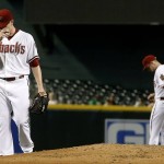 Arizona Diamondbacks' Jeremy Hellickson, left, shows his frustration after overthrowing to second base and Chris Owings, right, for an error, allowing San Diego Padres' Cory Spangenber to reach second base during the first inning of a baseball game Monday, Sept. 14, 2015, in Phoenix. (AP Photo/Ross D. Franklin)