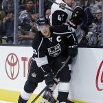 Los Angeles Kings right wing Dustin Brown, left, checks Arizona Coyotes' Alex Grant during the second period of an NHL preseason hockey game in Los Angeles, Tuesday, Sept. 22, 2015. (AP Photo/Chris Carlson)
