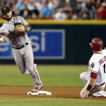 San Francisco Giants shortstop Brandon Crawford, left, turns the double play while avoiding Arizona Diamondbacks' A.J. Pollock on a ball hit by Ender Inciarte in the first inning during a baseball game Monday, Sept. 7, 2015, in Phoenix. (AP Photo/Rick Scuteri)