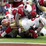 San Francisco 49ers running back Carlos Hyde (28) is tackled in the end zone for a safety by Arizona Cardinals strong safety Deone Bucannon (20) and Kevin Minter, bottom, during the second half of an NFL football game, Sunday, Sept. 27, 2015, in Glendale, Ariz.  (AP Photo/Ross D. Franklin)