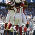 Arizona Cardinals wide receiver Larry Fitzgerald (11) celebrates a touchdown reception with running back Chris Johnson (23) and offensive tackle Earl Watford during the second half of an NFL football game against the Chicago Bears, Sunday, Sept. 20, 2015, in Chicago. (AP Photo/Michael Conroy)