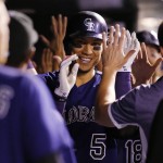 Colorado Rockies' Carlos Gonzalez is congratulated by teammates in the dugout after hitting a grand slam off Arizona Diamondbacks relief pitcher Keith Hessler during the seventh inning of a baseball game Wednesday, Sept. 2, 2015, in Denver. (AP Photo/Jack Dempsey)